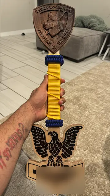 Military Working Dog paddle: Carved K9 shield head, paracord-wrapped grip and a carved Navy rating eagle on the blade.