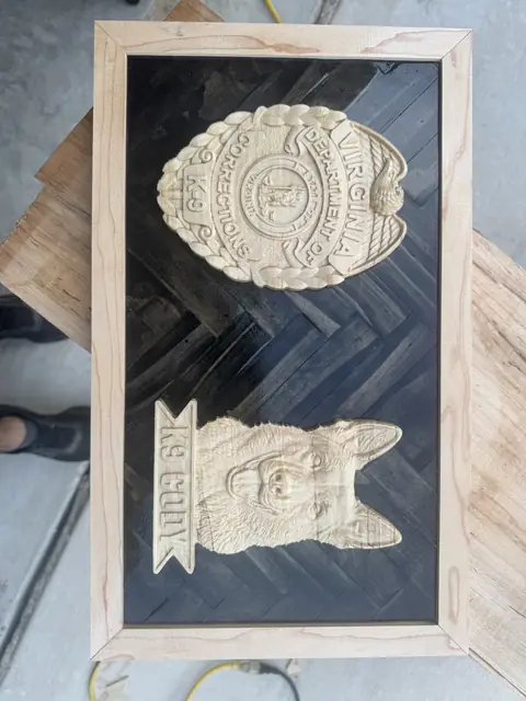 K9 unit shadow box: Carved agency badge and K9 head over a dark herringbone field, hard maple frame.