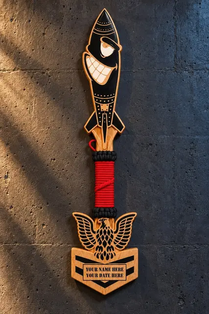 Paddle with paracord grip (design example): Hardwood paddle with a red paracord-wrapped handle and a carved eagle. Name and date panels are filled in for your order.